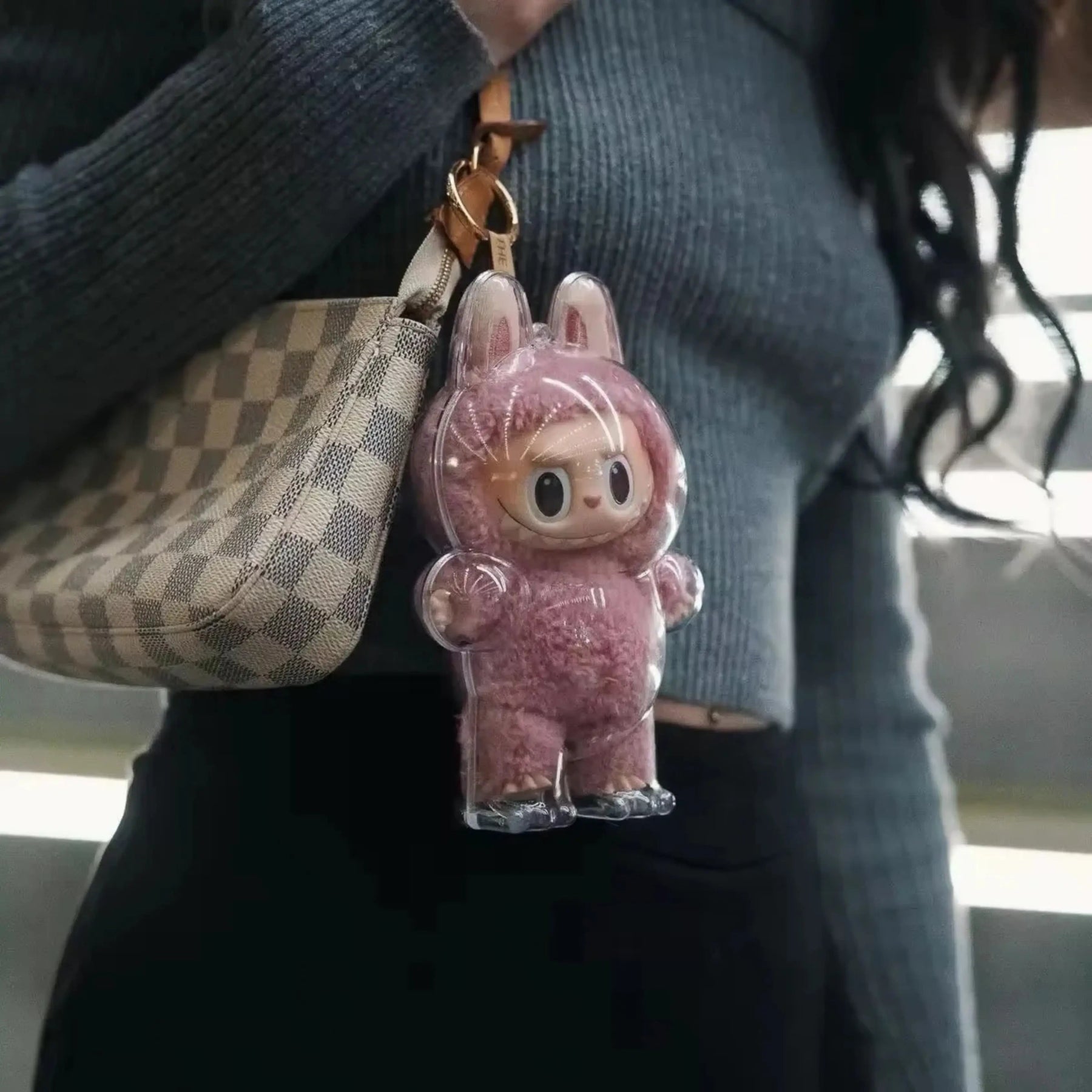 Boneco Labubu rosa da Popmart com capa protetora usado como acessório em bolsa, ideal para fãs de cultura pop