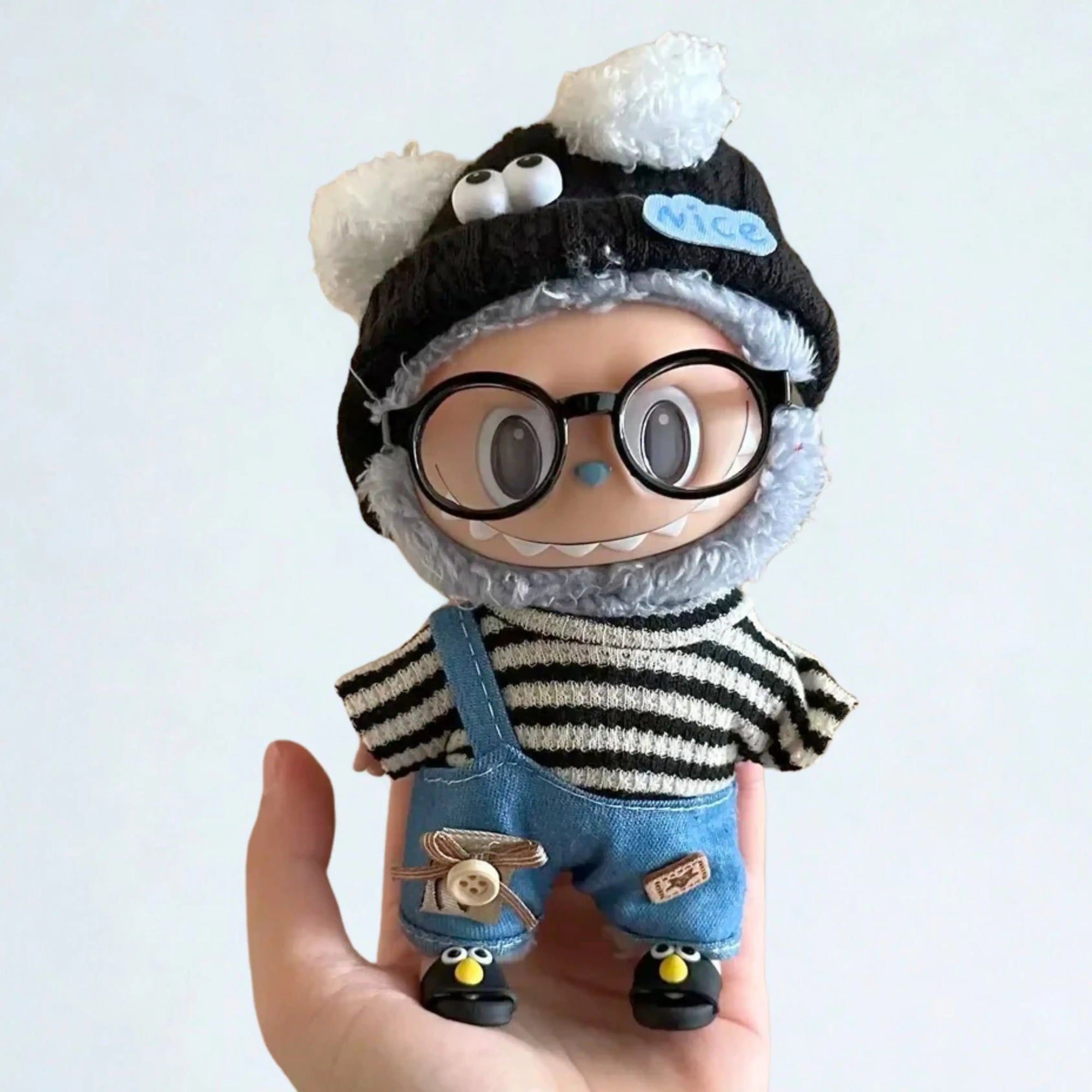 Boneco Labubu Popmart com roupa preta, óculos redondos e sapatos com olhos, usando kit fashion colecionável