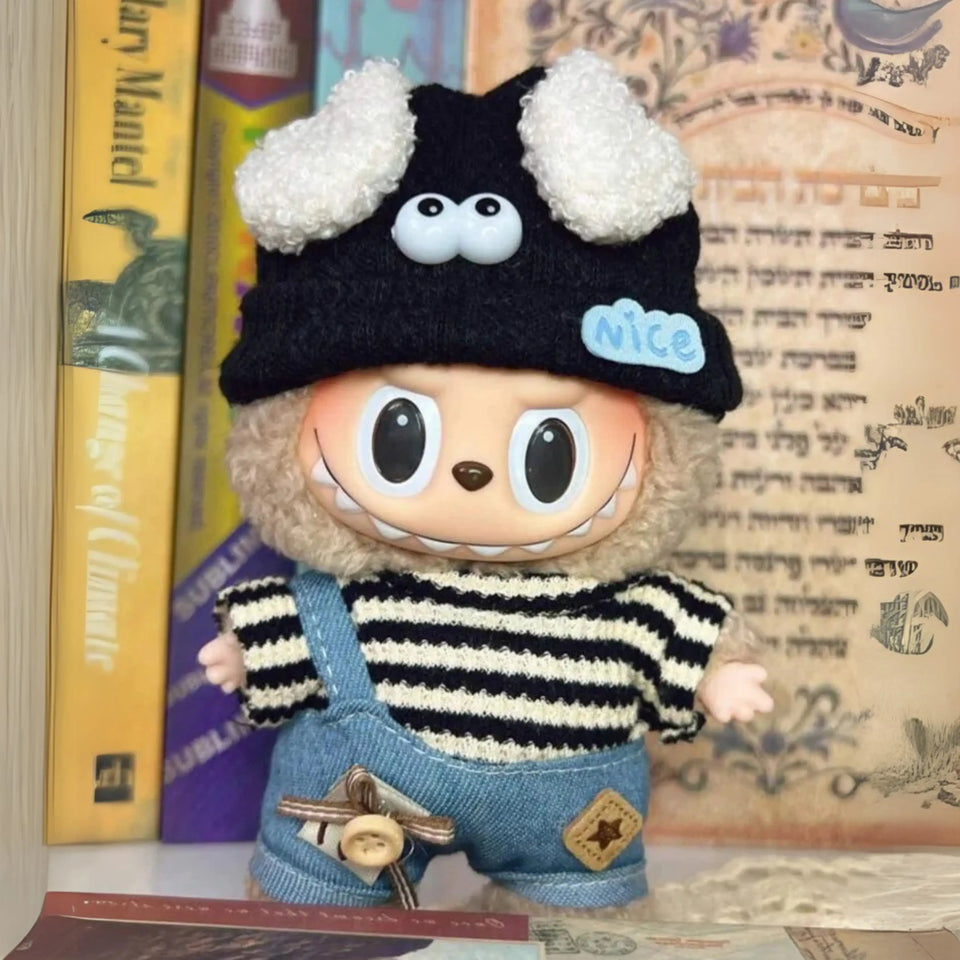 Labubu Popmart com touca preta de olhos grandes, jardineira jeans e blusa listrada preta e branca estilo casual